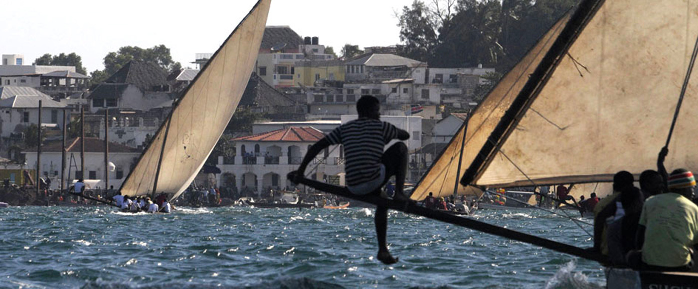 régate de dhows devant la ville de Lamu au Kenya avec spectateurs