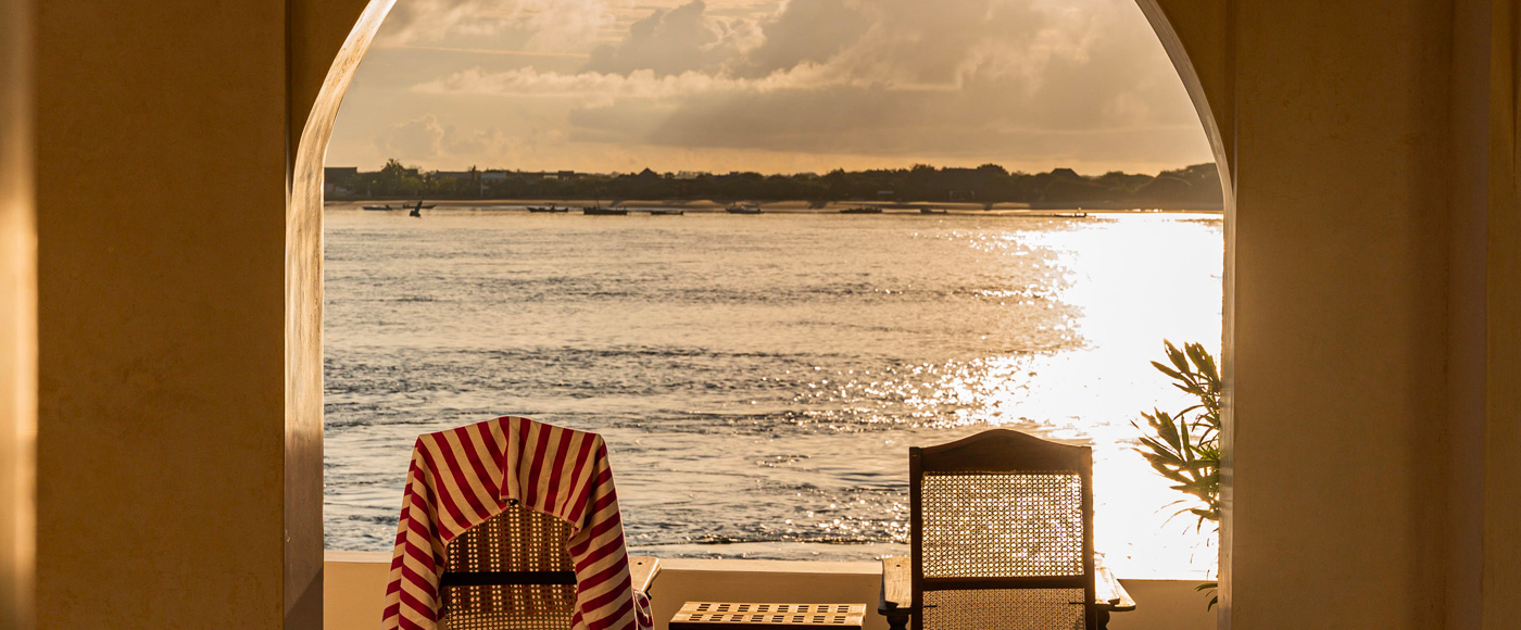 terrasse de la villa à Shella Beach sur l’île de Lamu au Kenya avec fauteuils face à l’océan au coucher du soleil