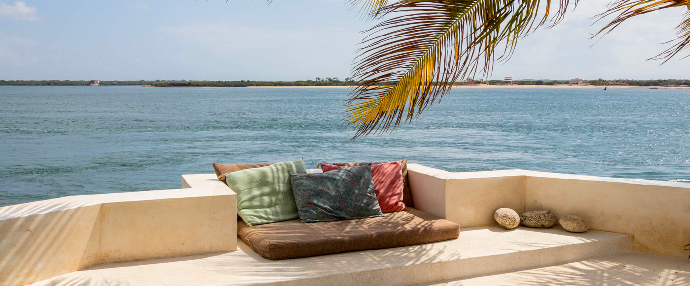 terrasse avec coussins sous les palmiers face à l’océan à Shella Beach sur l’île de Lamu au Kenya